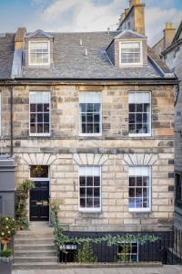 een oud stenen huis met een zwarte deur bij Eleven Stafford Street Townhouse in Edinburgh