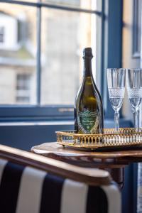 una botella de vino sentada en una mesa con dos copas en Eleven Stafford Street Townhouse en Edimburgo