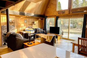 una sala de estar con paredes de madera y una gran ventana. en River Bend Chalet, en Sunriver