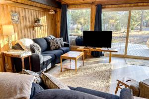 sala de estar con sofá y TV en River Bend Chalet, en Sunriver