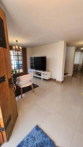 an empty living room with a television and a door at casa campestre escobero in Envigado