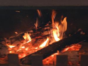 fuego en una chimenea de ladrillo por la noche en Casa do Castanheiro, en Outeiro