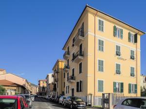 un edificio giallo su una strada cittadina con auto parcheggiate di Da Eufemia apartment for 4 guests a La Spezia