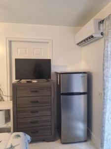eine Küche mit einem Kühlschrank und einem TV auf einer Kommode in der Unterkunft Brand new studio apartment in Vero Beach