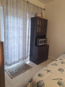 a bedroom with a microwave on a dresser next to a window at Brand new studio apartment in Vero Beach
