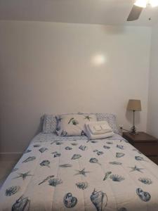 a bed in a bedroom with a blanket on it at Brand new studio apartment in Vero Beach