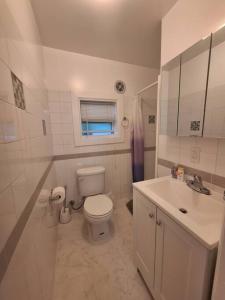 a white bathroom with a toilet and a sink at Brand new studio apartment in Vero Beach