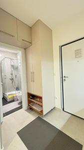 a room with a bathroom with a shower and a door at Apartman Sunce Bjelasnica in Bjelašnica