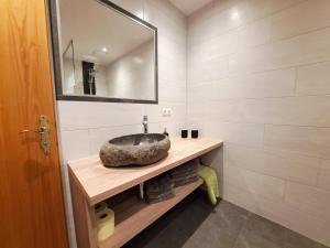 uma casa de banho com um lavatório de pedra e um espelho. em Apart Dahuam em Aschau