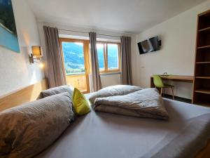 um quarto de hotel com duas camas e uma janela em Apart Dahuam em Aschau