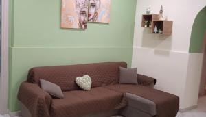 een woonkamer met een bruine bank met 2 foto's bij La dimora dei Mori Gela in Gela