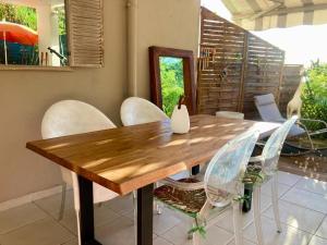 a dining room with a wooden table and white chairs at La Terrasse in Le Carbet