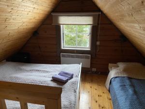 1 dormitorio con 2 camas en una cabaña de madera en Tiku puhketalu, en Kiidjärve
