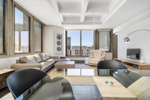 a living room with a couch and a table at Luxury Cartwrights Corner Apartments with Juliette balconies in Cape Town