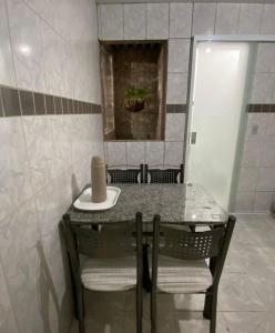 uma mesa com cadeiras e um lavatório num quarto em Aconchego de Maria em Piranhas