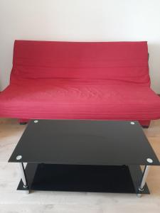 eine rote Bank mit einer roten Decke drauf. in der Unterkunft Studio meublé avec balcon in Perpignan