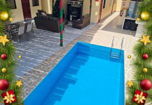 a blue swimming pool in front of a building with christmas trees at La Ruta in Paracas