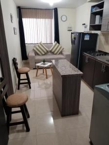 a kitchen and living room with a couch and a table at APARTAESTUDIO en el Norte de Armenia, en la via a Salento y Filandia Con parqueadero de carro in Armenia