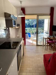 a kitchen and living room with a view of a patio at Agréable Studio Sanary-sur-mer in Sanary-sur-Mer