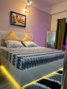 een slaapkamer met een kingsize bed met paarse muren bij Serene Stay India in Greater Noida