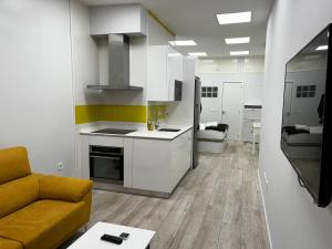 una cucina e un soggiorno con un divano e un tavolo di Exyca Tetuán a Madrid