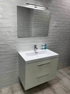 uma casa de banho com um lavatório branco e um espelho. em Exyca Tetuán em Madri