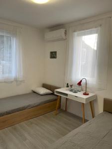 een kleine slaapkamer met een bed en een bureau bij Lipite Guest House 
