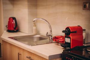 a kitchen counter with a sink and a red appliance at Nicolas Luxury Suites in Kourouta