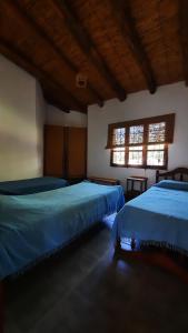 two beds in a room with two windows at La casona de Adobe in San José