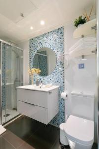 y baño con aseo, lavabo y espejo. en Bonito apartamento en Sol, en Madrid