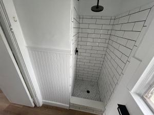 a bathroom with a shower with white subway tiles at Deland Motel in DeLand