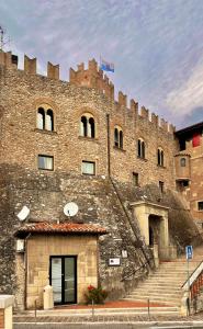 um grande edifício de tijolos com escadas em frente em Serravalle Castle Apartment em Serravalle