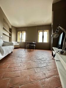 a large room with a stone floor with a bed and a table at Serravalle Castle Apartment in Serravalle