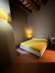 um quarto com uma cama com uma colcha amarela em Serravalle Castle Apartment em Serravalle