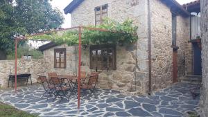a table and chairs in front of a stone building at Casas Quo Vadis -Azul in Lugo