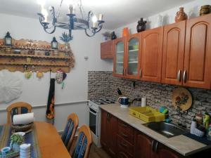 kuchnia z drewnianymi szafkami, zlewem i stołem w obiekcie Chata na Čertove w mieście Lazy pod Makytou