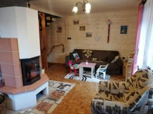 a living room with a couch and a fireplace at Chata na Čertove in Štôla +31 photos