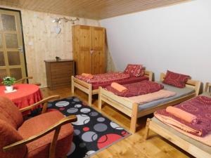 a room with two beds and a table and chairs at Chata na Čertove in Štôla