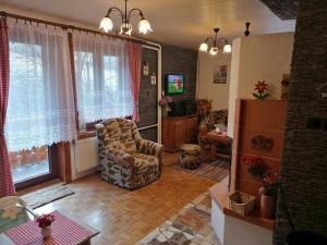 a living room with a chair and a refrigerator at Chata na Čertove in Štôla