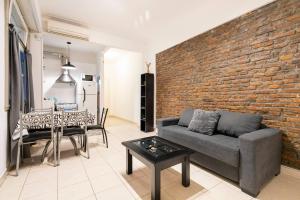 a living room with a couch and a brick wall at Ideal 3 ambientes c/ homeoffice. Palermo-V.Crespo in Buenos Aires