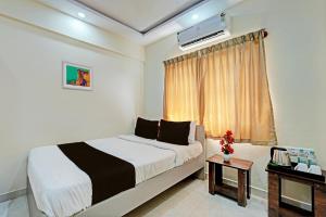 a hotel room with a bed and a window at Collection O Cka Boarding And Lodging in Yelahanka