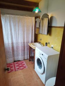 ein Badezimmer mit einer Waschmaschine und einem Waschbecken in der Unterkunft Cabaña de Alejandro in La Paloma