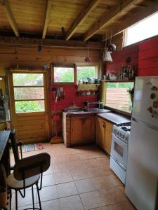 uma cozinha com paredes vermelhas e um frigorífico branco em Cabaña de Alejandro em La Paloma