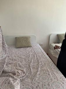 1 cama con edredón y almohadas en Hospedaje Alitay, en Otavalo