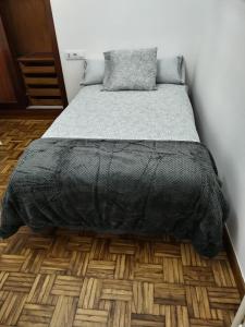 1 cama con edredón negro en una habitación en OLIVA 18, en Pontevedra