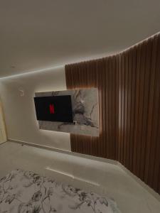 a living room with a tv on the wall at استديو مع جلسة خارجية بدخول ذكي in Riyadh