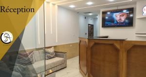 a waiting room with a couch and a tv on the wall at Hostel SA Bab Ezzouar in Le Lido