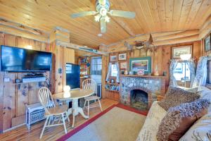 a living room with a couch and a table with a fireplace at Autumnsong Fireside Cabin Near Dtwn Buena Vista! in Buena Vista