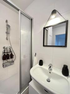 La salle de bains blanche est pourvue d'un lavabo et d'une douche. dans l'établissement Penthouse near Central Station with free parking, à Vienne