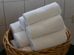 - un panier rempli de serviettes blanches dans la salle de bains dans l'établissement Ferienwohnung Backbord, à Werdum
